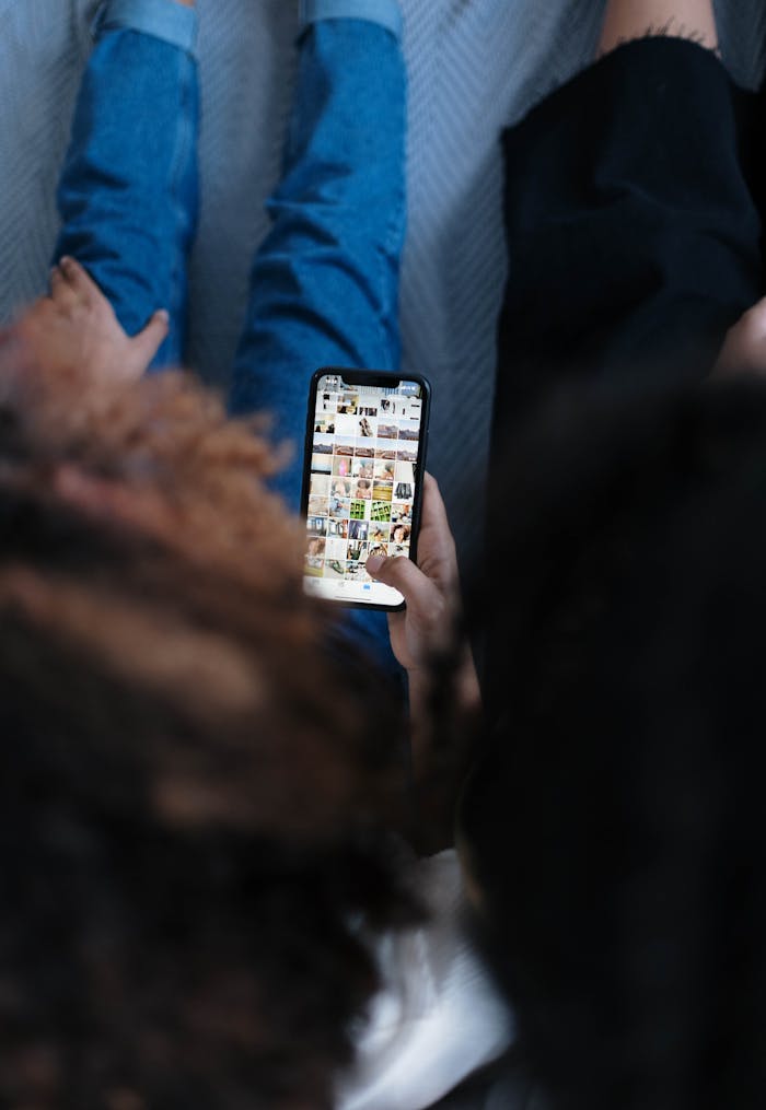 About Two people viewing a smartphone together, sharing social media content indoors.